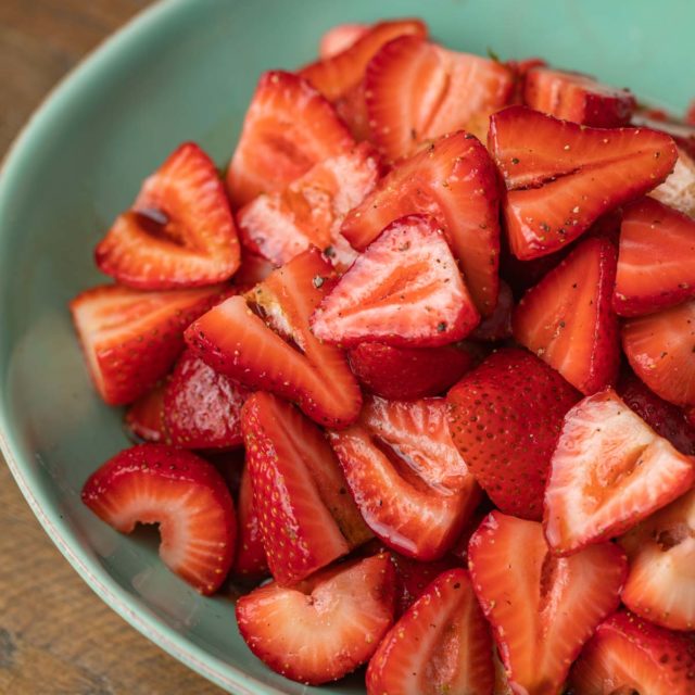 Balsamic Strawberries with black pepper in green bowl
