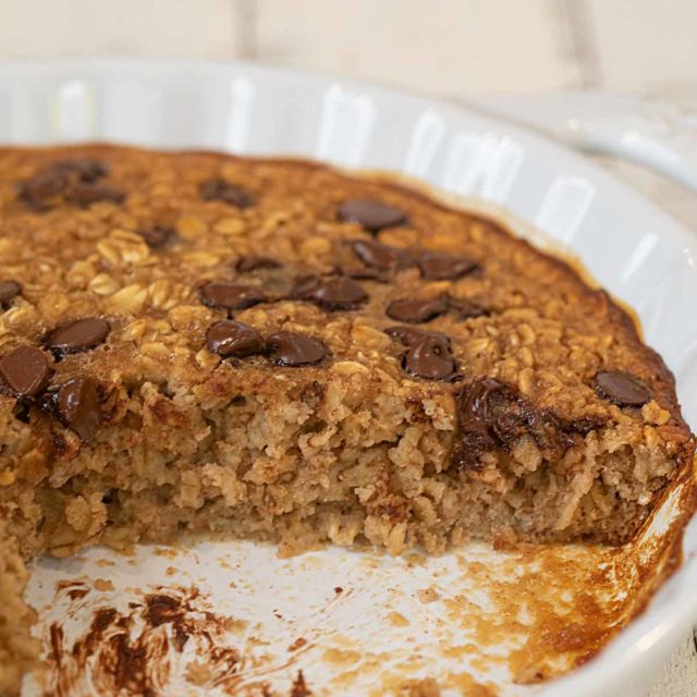 Chocolate Chip Baked Oatmeal in pie plate with slice removed