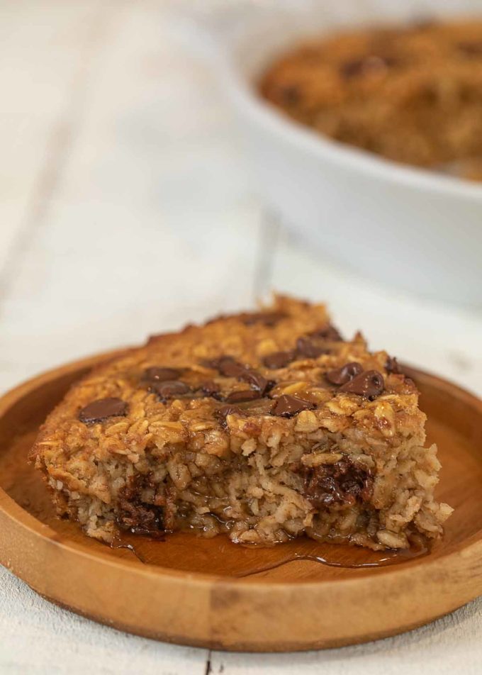 Chocolate Chip Baked Oatmeal slice on plate with maple syrup