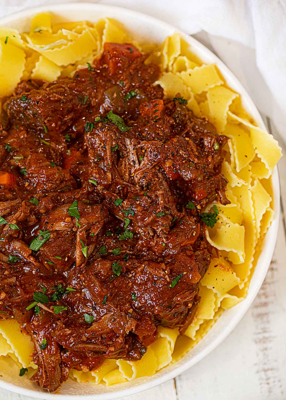 Healthier Beef Ragu over Pasta in white bowl