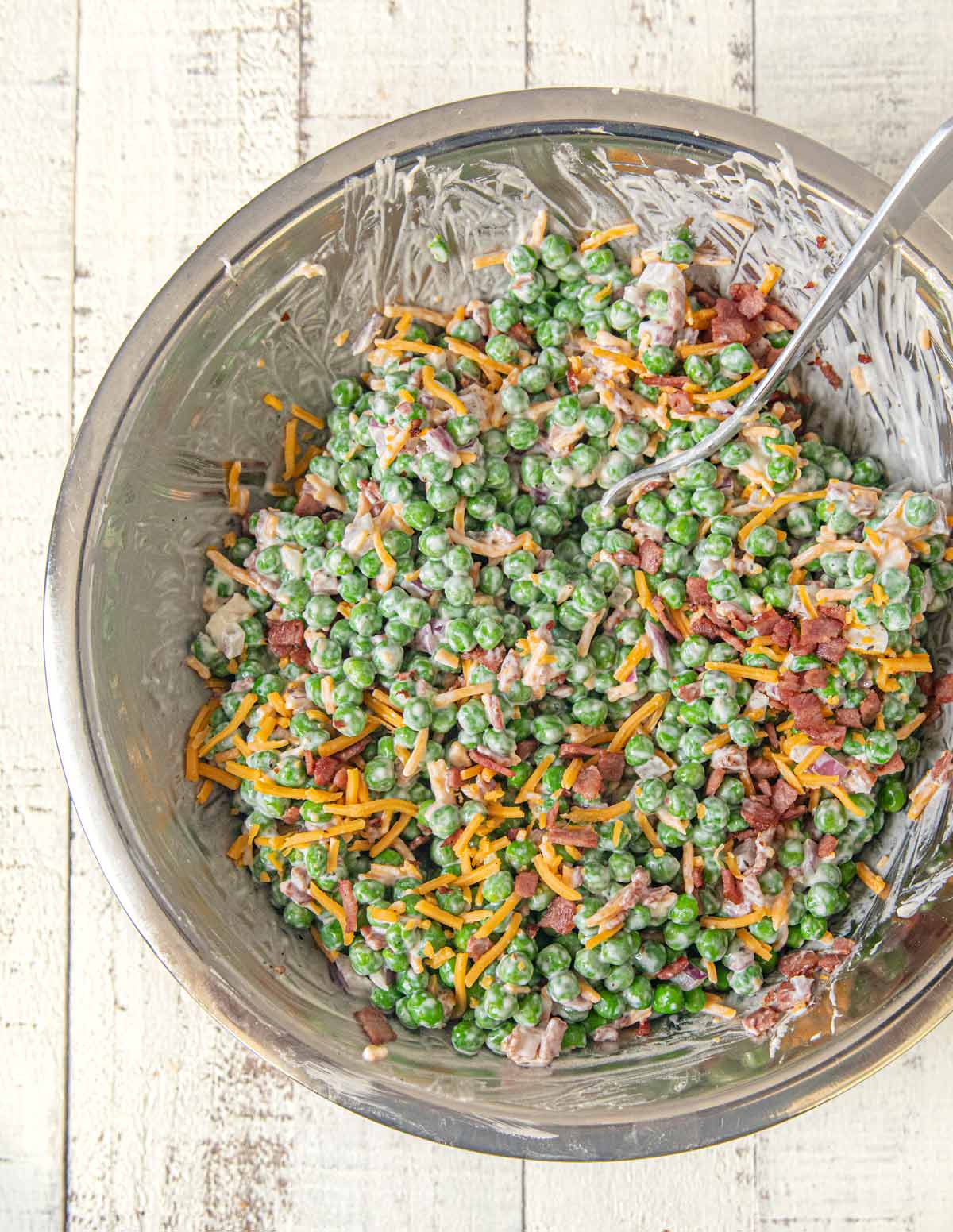 Healthy Pea and Bacon Salad mixed in mixing bowl