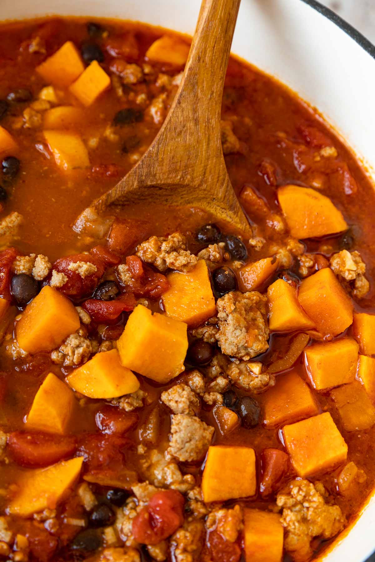 Turkey Sweet Potato Chili in pot with wooden spoon