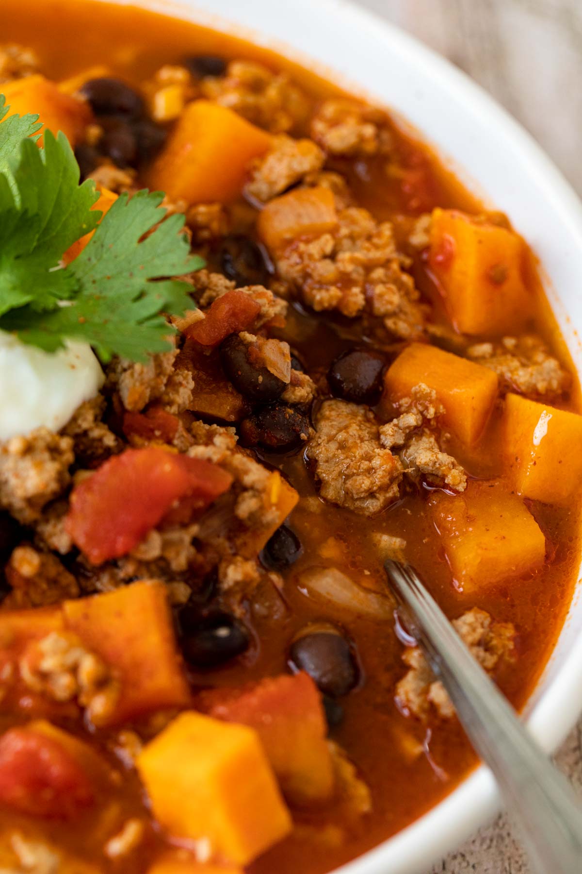 Turkey Sweet Potato Chili in bowl with spoon upclose