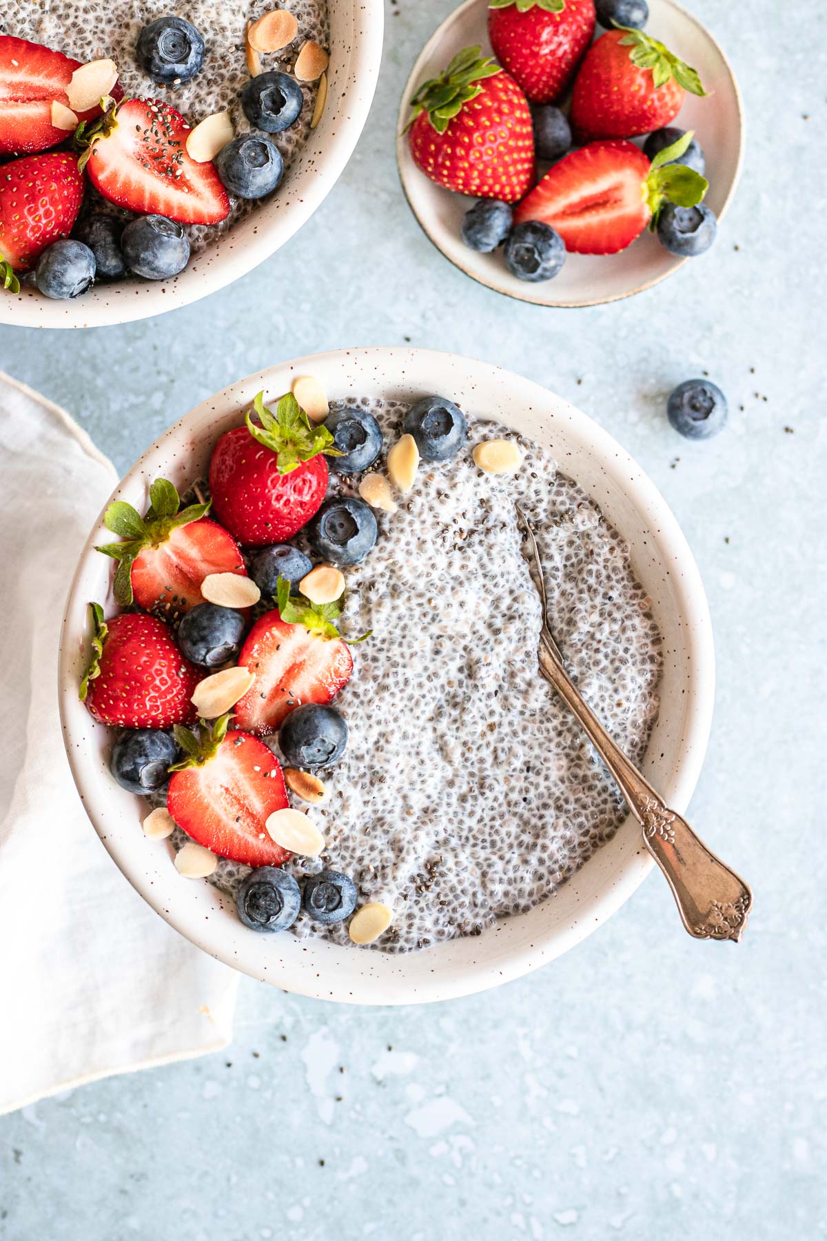 Vanilla Chai Pudding in bowl with berries on top and spoon in the bowl