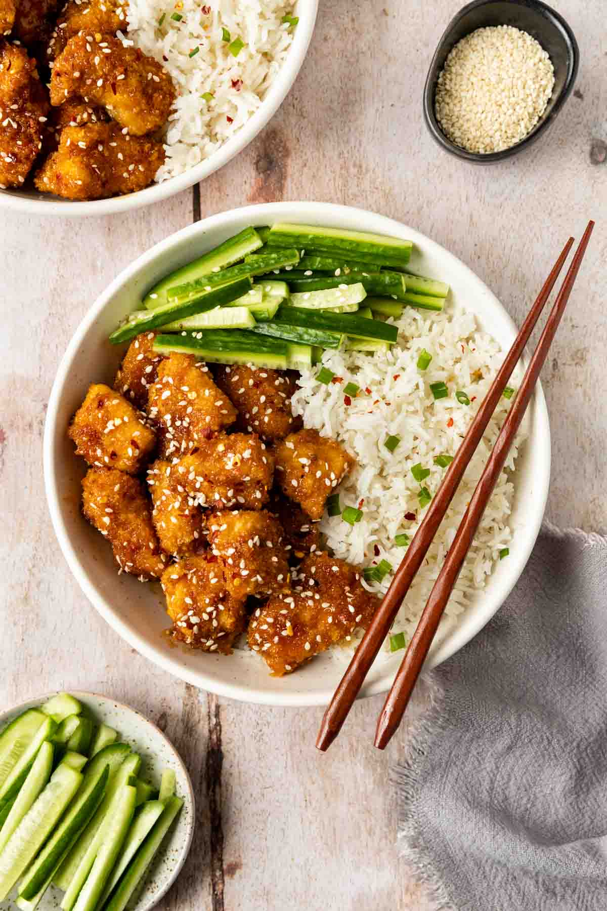 Baked Sesame Chicken in a bowl with chopsticks 