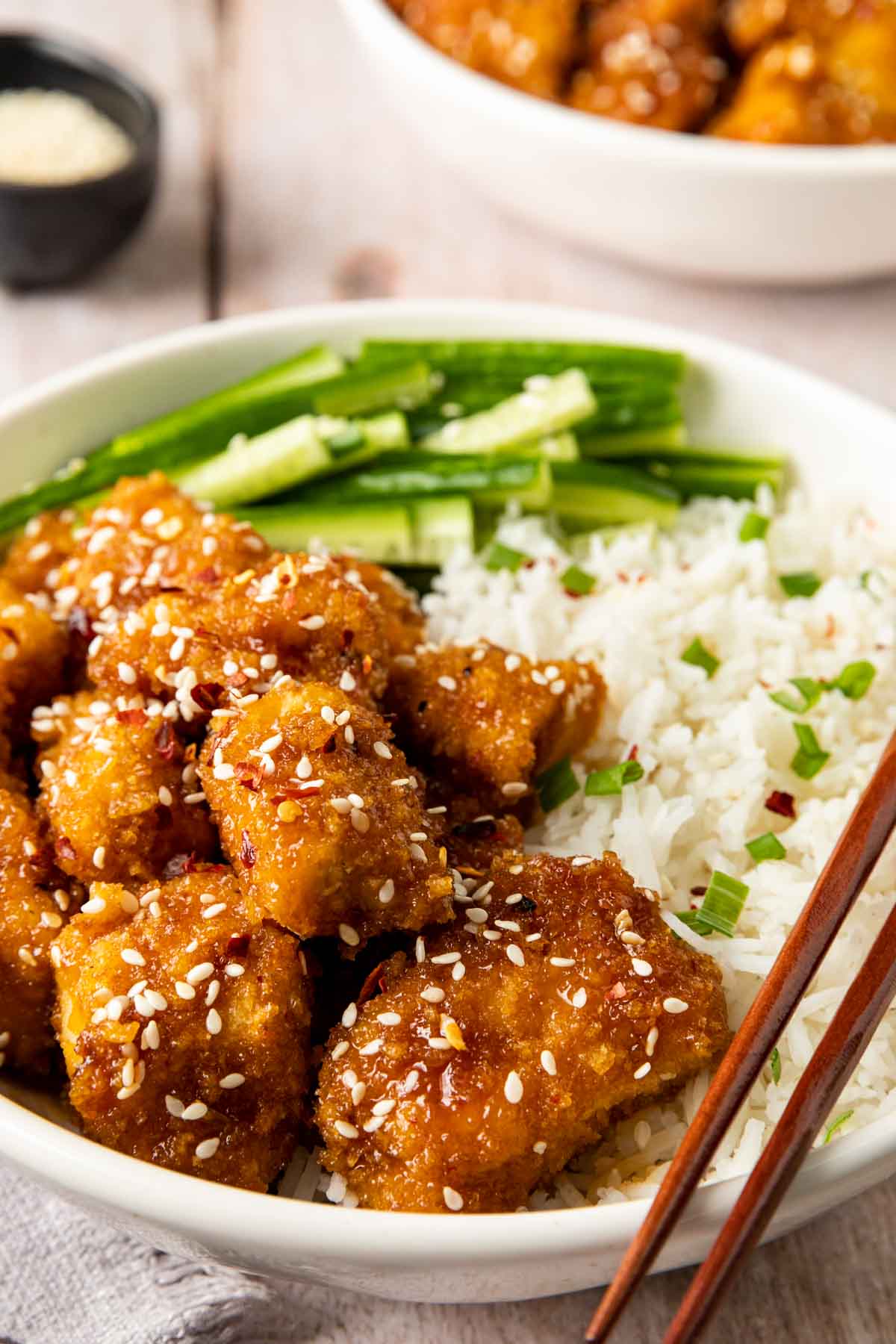 Baked Sesame Chicken in bowl with chopsticks