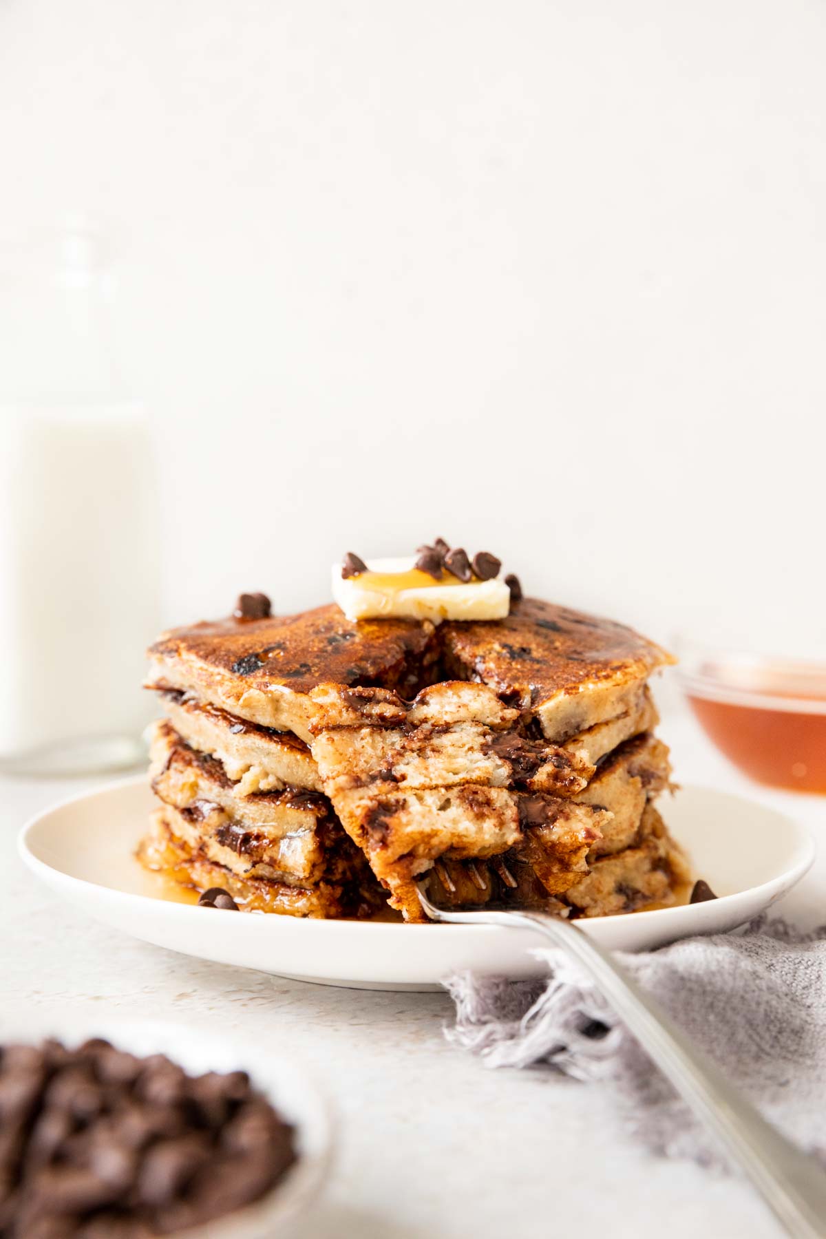 Whole Wheat Chocolate Chip Pancakes up close with butter on top and fork with bite