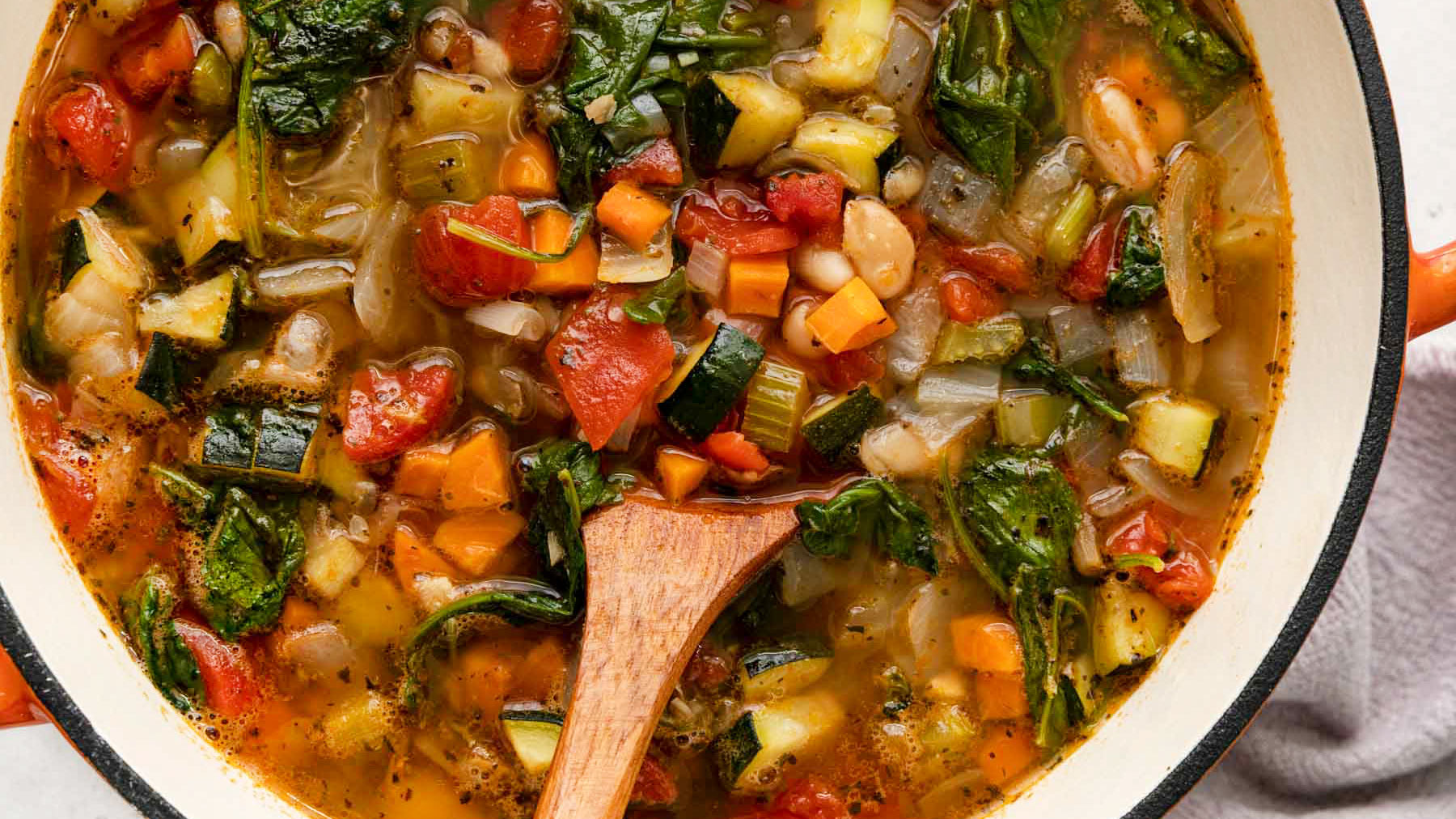 Tuscan-Vegetable-Soup in pot with wooden spoon