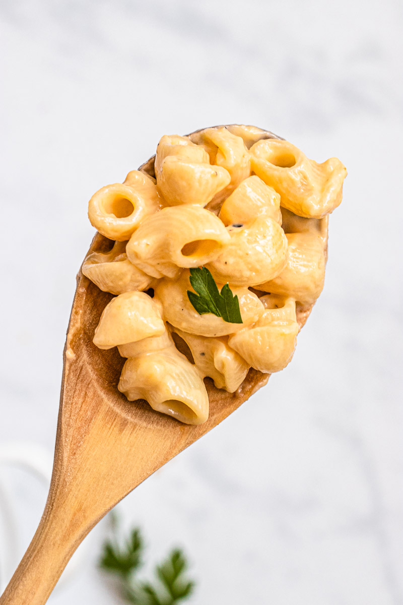 Healthy Creamy Macaroni and Cheese on a wooden spoon