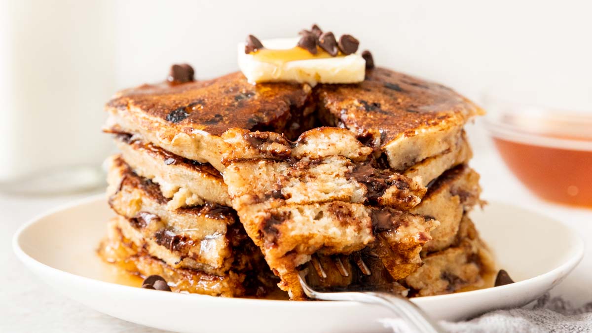 Whole Wheat Chocolate Chip Pancakes up close with butter on top and fork with bite