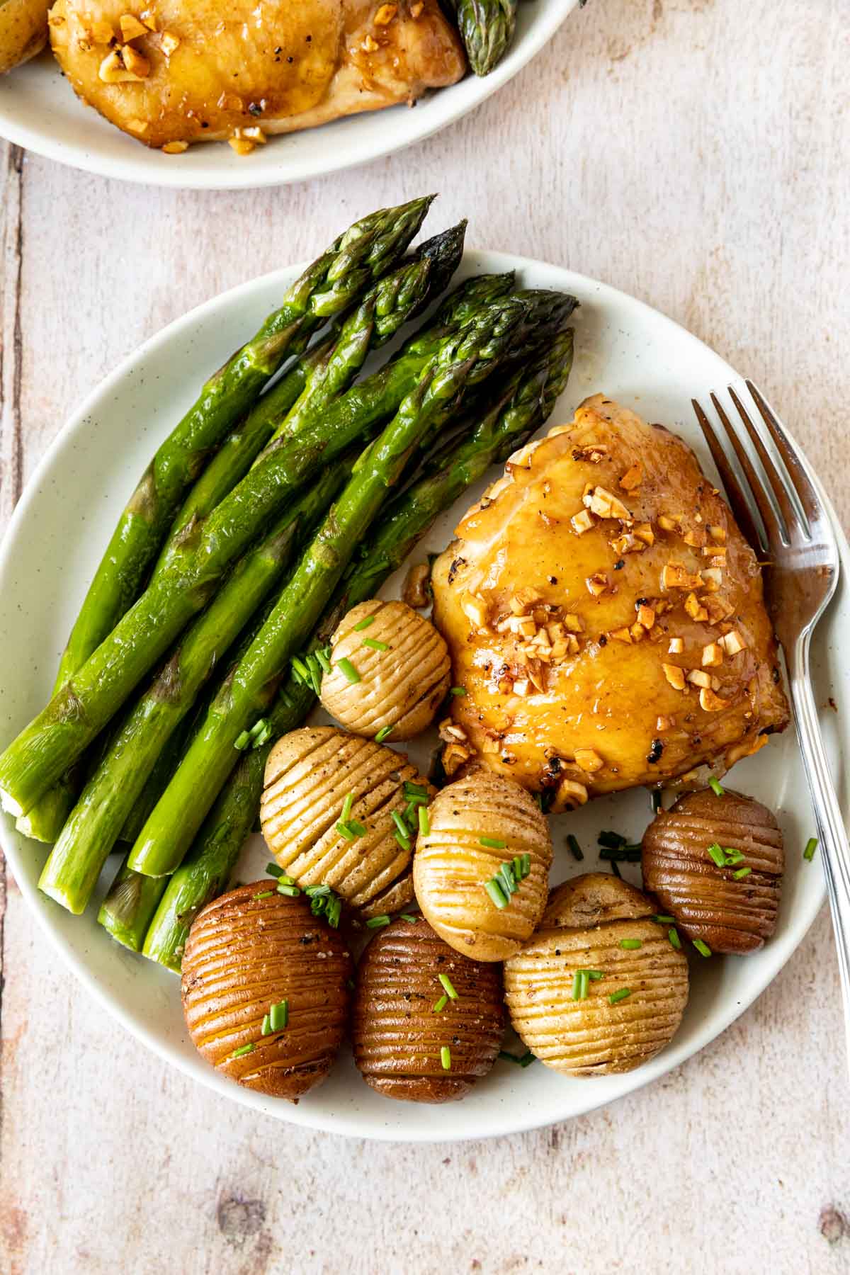 Roasted Garlic Chicken on plate with asparagus and hassel-beck potatoes