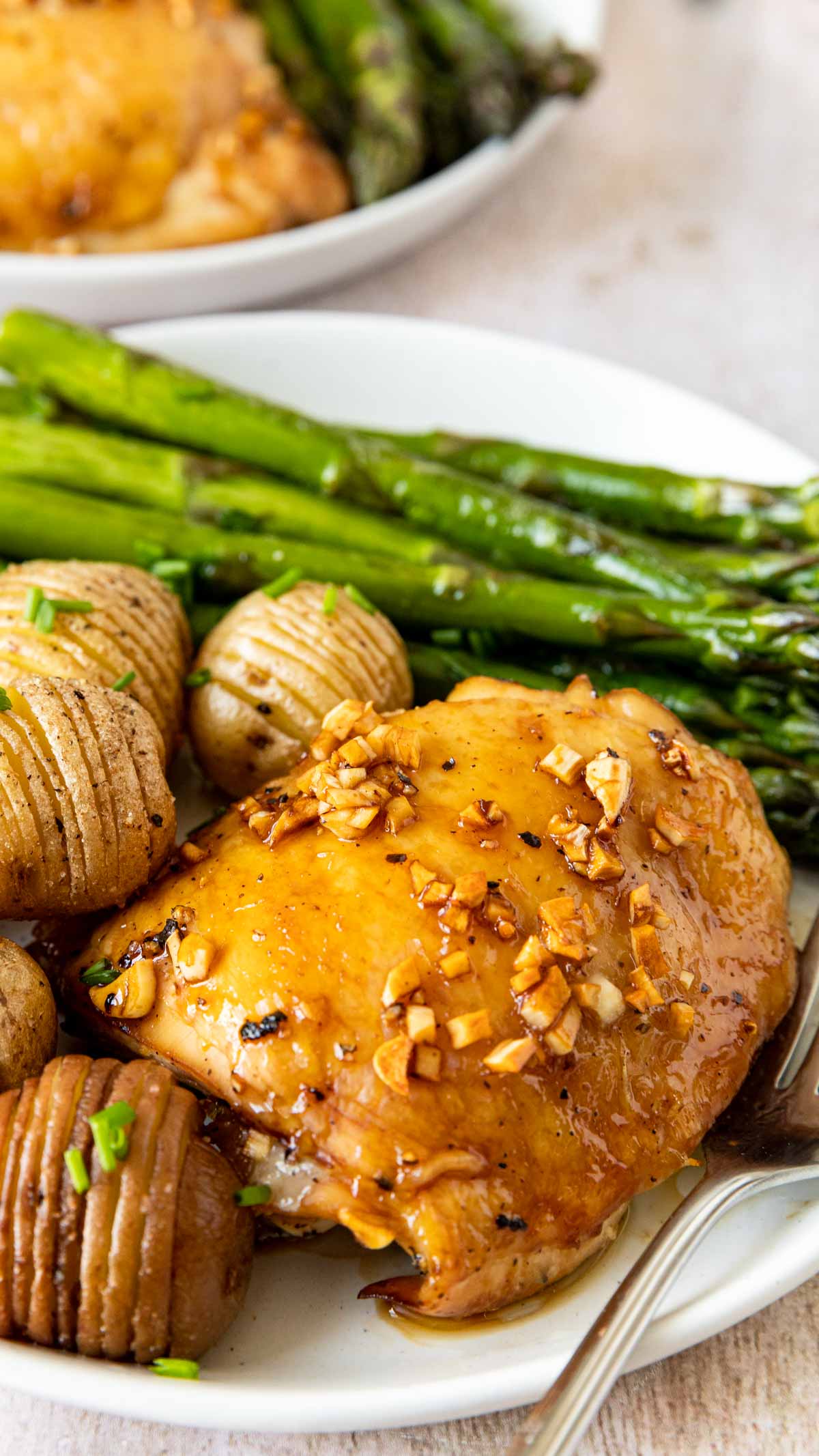 Roasted Garlic Chicken on plate with asparagus and hassel-beck potatoes up close