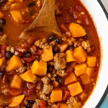 Turkey Sweet Potato Chili in pot with wooden spoon