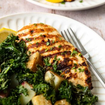 Sheet Pan Roasted Garlic Chicken with Kale and Potatoes on a plate with a fork